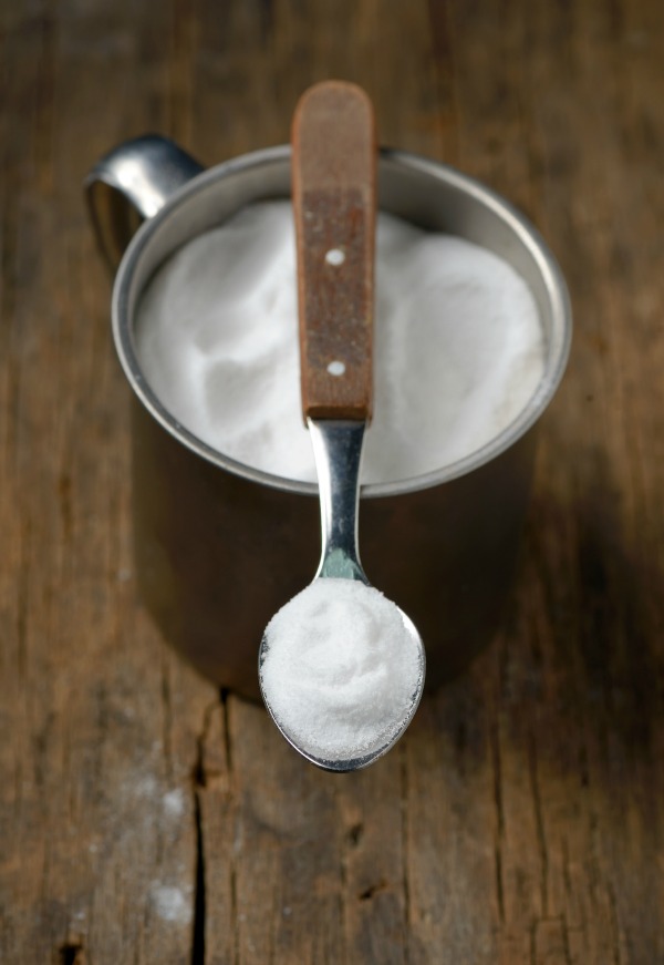 Spoonful of sodium bicarbonate on old wood table